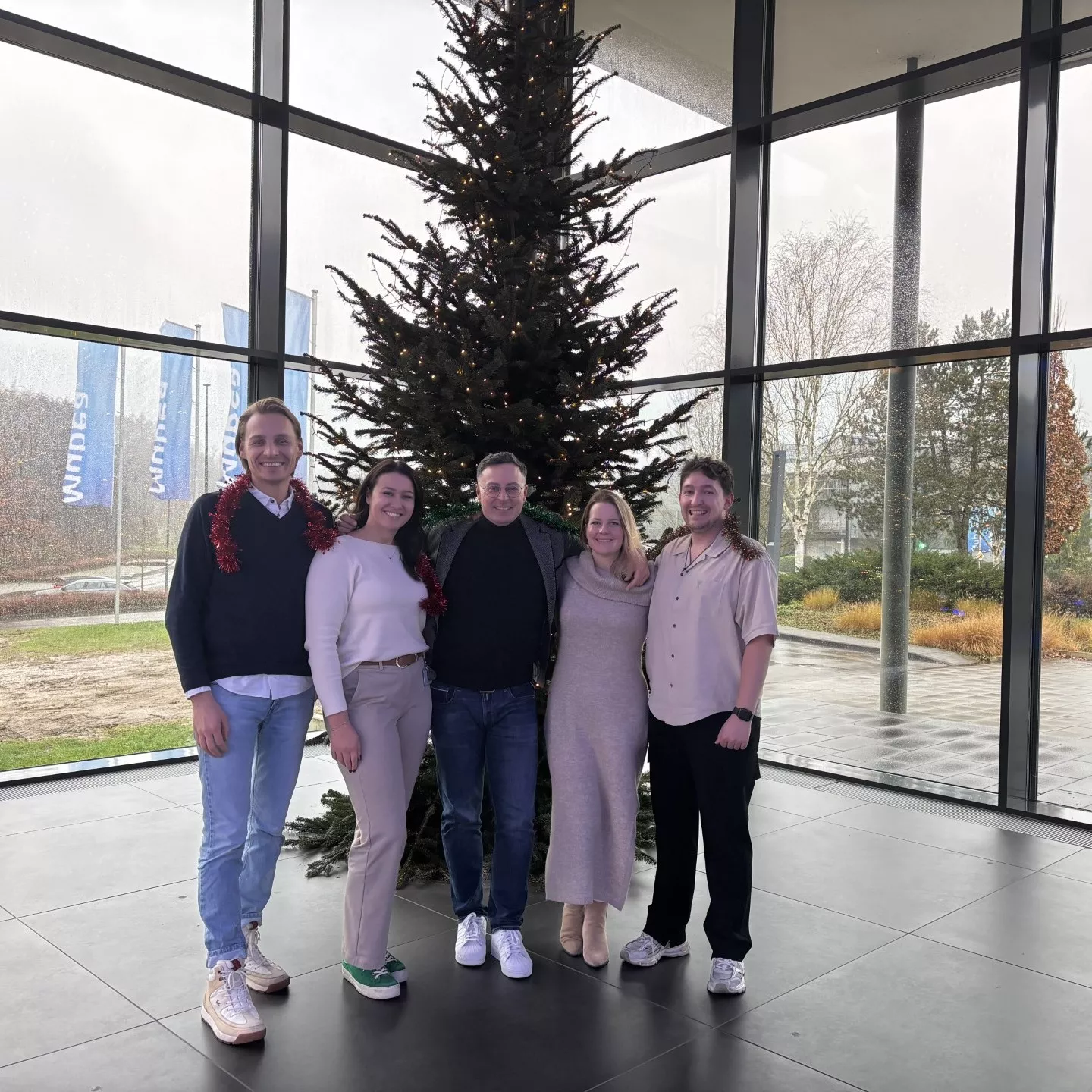 Das Team feiert die Weihnachtszeit mit Freude und Zusammenhalt unterm festlich geschmückten Baum