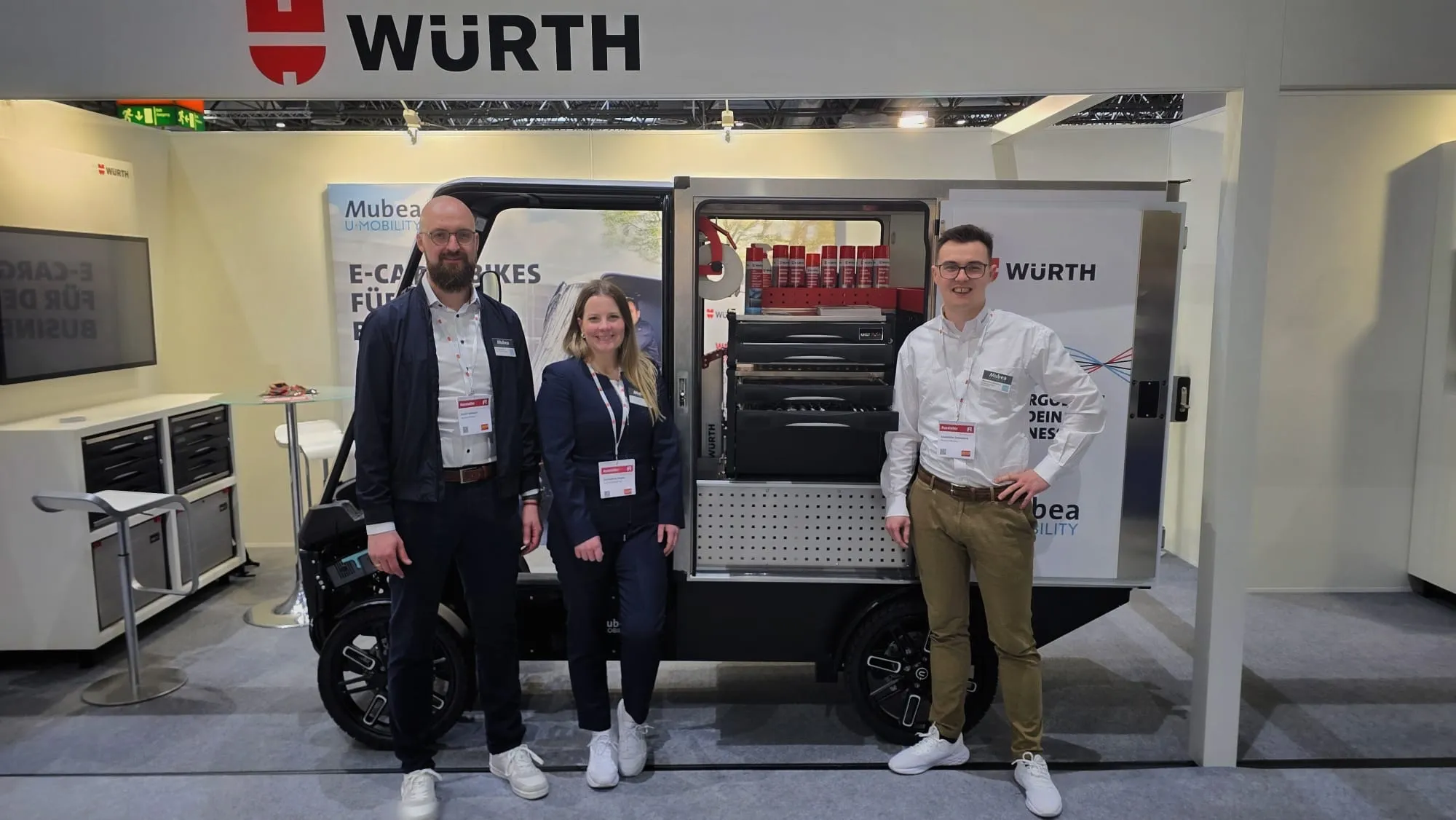 Messestand von Würth mit Mubea E-Cargobike und drei Personen