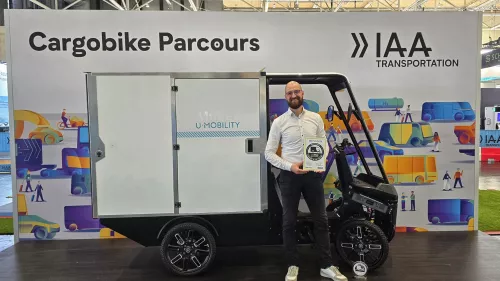 IAA: Mubea employee holding the "Cargo Bike of the Year" award in front of the Cargo PACK