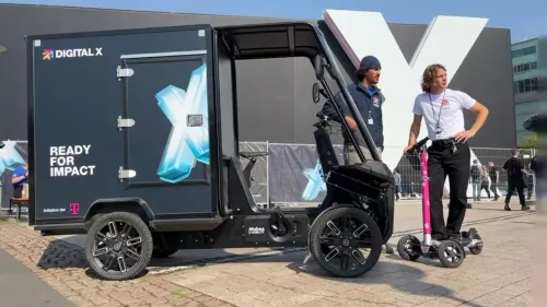 Digital X 2024: Cargo bike and e-scooter with riders in front of a Digital X building