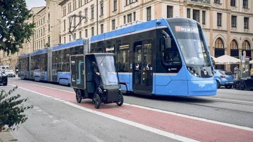 Cargo PACK und Strassenbahn fahren parallel aneinander vorbei
