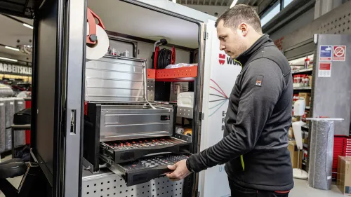 Junger mann sieht in die Seitentür des Würth E-Cargobikes.
