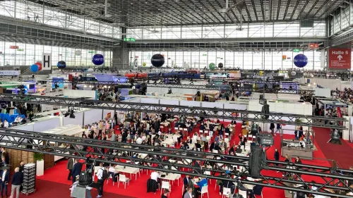 Große Messehalle mit vielen Ständen und Besucher:innen auf der Flotte! Branchenveranstaltung
