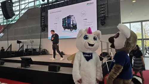 Vortrag auf Messebühne zu Mubea E-Cargobike, zwei Maskottchen im Vordergrund