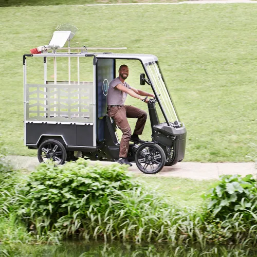 Junger Parkarbeiter fährt im grünen Park mit dem WORK.