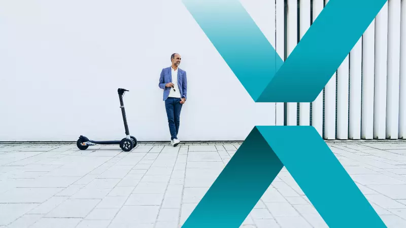 Ein Mann in Freizeitkleidung lehnt lässig an einer weißen Wand. Neben ihm steht ein schlanker E-Scooter auf einer gefliesten Fläche. Im Vordergrund sind große, sich überschneidende, türkisfarbene geometrische Formen, die dem Bild ein modernes und dynamisches Aussehen verleihen.